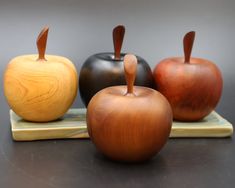 three wooden apples sitting on top of a tray