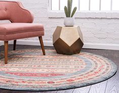 a pink chair sitting on top of a rug next to a potted cactus in a living room