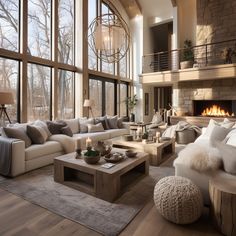 a living room filled with lots of furniture next to large windows and a fire place