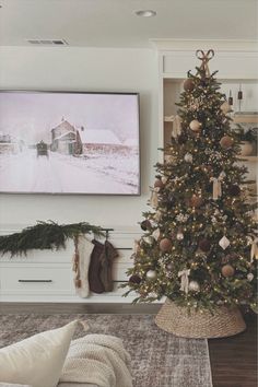 a living room with a christmas tree in the corner and pictures on the wall behind it