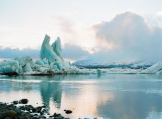 icebergs are floating in the water near rocks