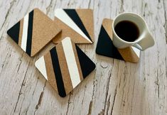 four coasters with black and white stripes on them next to a cup of coffee