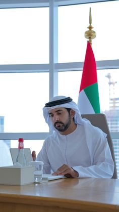 a man sitting at a desk in front of a laptop computer