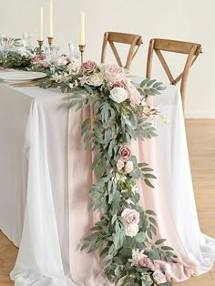 the table is decorated with flowers and greenery for an elegant wedding or special event