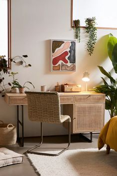 a room with a desk, chair and potted plants