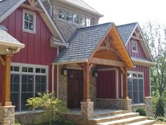 a red house with stone steps leading up to the front door and covered porch area