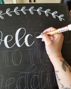 a person writing on a chalkboard with marker