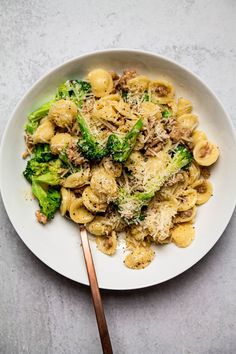 a white plate topped with pasta and broccoli