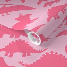 a pink and white wallpaper with dinosaur silhouettes on the side, along with a roll of tape