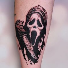 a person with a knife and skull tattoo on their leg