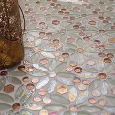 a vase sitting on top of a table covered in lots of different colored glass discs