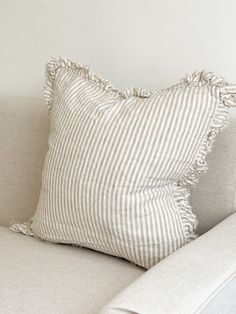 a striped pillow sitting on top of a white couch