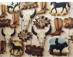 decorated cookies are arranged in the shape of cow heads and other animal related items on a wooden surface