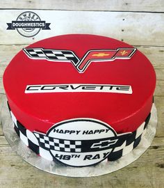 a red cake with the chevrolet logo on it is sitting on top of a wooden table