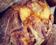 baked bread with oranges and raisins on it sitting in a pile next to other pastries