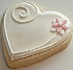 a cookie shaped like a heart with a flower on it