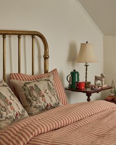 a bed with red and white striped sheets in a bedroom next to a night stand