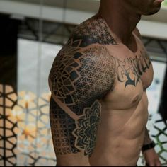 a man with tattoos on his arm and shoulder