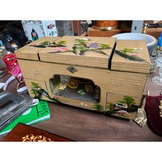 an old fashioned wooden box with flowers painted on the side and wheels attached to it