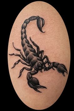 a scorpion tattoo on the back of a man's arm, with black ink