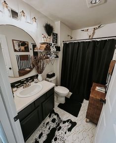 a bathroom with a black and white rug on the floor next to a shower curtain