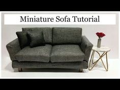 a couch sitting next to a small table with a vase on it and the words miniature sofa