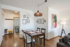 the dining room table is set for four with place settings on it and pictures hanging up against the wall