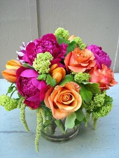 a vase filled with lots of different colored flowers