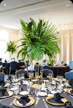 a table set up with plates, silverware and a potted plant in the center