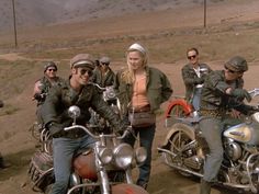 a group of people riding on the back of motorcycles