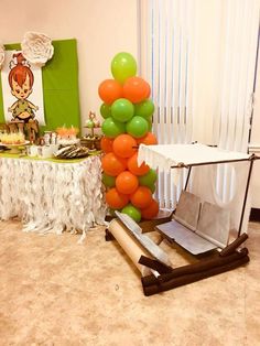 a table topped with lots of orange and green balloons