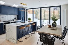 an image of a kitchen with blue cabinets and marble counter tops in the middle of it