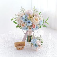 a bouquet of flowers sitting on top of a table next to a small card holder