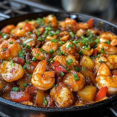 a skillet filled with shrimp and vegetables on top of a stove