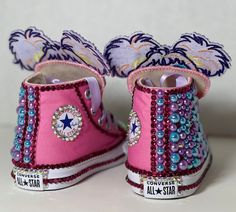 a pair of pink shoes with purple and blue beads