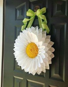 a green door with a white and yellow flower hanging from it's front side