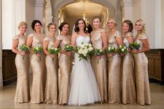 a group of women standing next to each other in front of a white and gold building