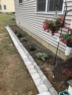 the garden is ready to be planted in front of the house, with flowers growing on the side