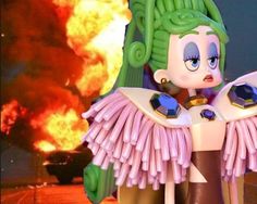 an animated character is standing in front of a large fire with flames coming out of it