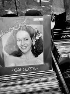 an old record player is sitting in front of a bunch of records that are stacked on top of each other