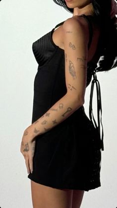 a woman with tattoos on her arm posing for the camera