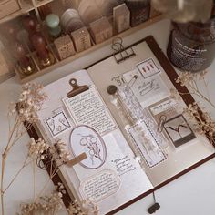 an open book sitting on top of a table next to some bottles and jars filled with writing