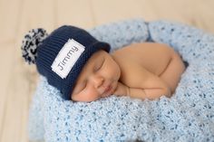 a newborn baby is sleeping in a blue crochet basket with a name tag on it