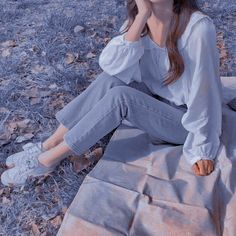 a woman sitting on the ground talking on her cell phone