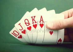 a hand holding four playing cards in front of a green background with the word j9ka on it