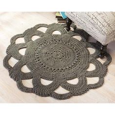 a crocheted doily sits on the floor next to a chair and books