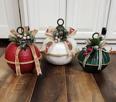 three decorative pumpkins decorated with ribbons and bows