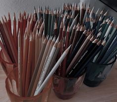 there are many pencils in the cup on the table and one is full of them