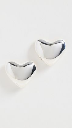 two silver spoons sitting next to each other on a white surface