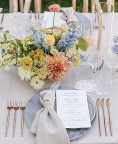 the table is set with flowers and silverware